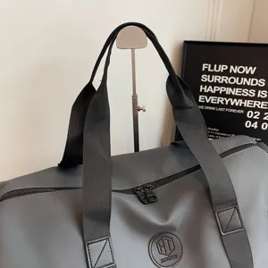 Sac de voyage gris avec poignées noires et logo, idéal pour le sport et les week-ends.