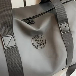 Vue détaillée du sac de voyage de sport gris de grande capacité avec sangles.