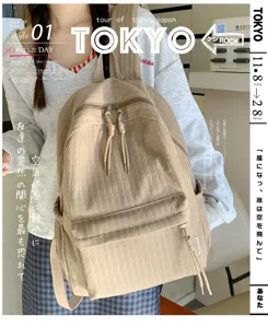 Vue détaillée d'un sac à dos beige stylé en tissu texturé avec fermeture à cordon double.