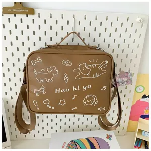 Cute brown canvas shoulder bag detail featuring playful cat and dog graphic prints for daily style.