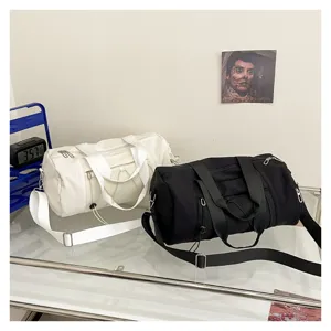 Detailed view of large capacity cylindrical gym sports bag with mesh pocket and shoulder strap.