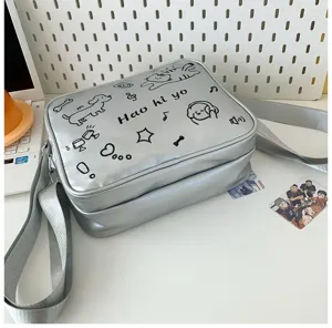 Silver ita messenger bag detail showing cute cat and dog doodle prints and adjustable shoulder strap.