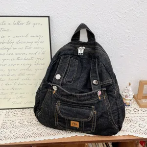 Dark denim vintage backpack detail showing texture, metal zippers, and unique retro style.