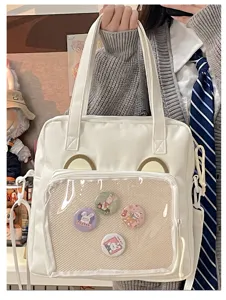 White ita bag with clear front pocket and cute ear design, perfect for pins and badges.