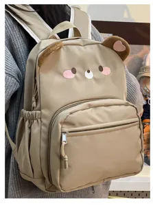 Dettaglio dello zaino carino con design da orsetto e pratiche tasche frontali spaziose.