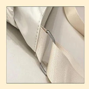 Detailed shot of casual crossbody bag adjustable strap with metal D-ring hardware and neat seams.