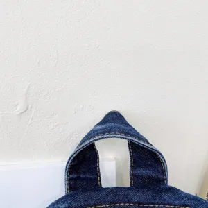 Close up of dark blue denim backpack handle strap, vintage casual daily school bag detail.