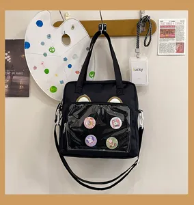 Black ita bag crossbody canvas shoulder bag with clear window and cute bear ears pins display.