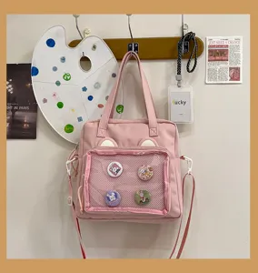 Cute pink ita bag with clear mesh pocket and bear ears, perfect for anime pins and daily use.
