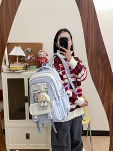 Detailansicht eines süßen hellblauen Schülerrucksacks am Model, mit praktischen Vordertaschen.