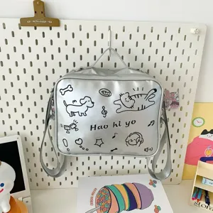 Silver shoulder bag detail showing cute cat dog doodles and embroidery design on glossy surface.