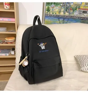 Detailed view of black canvas school backpack with cute baseball puppy embroidery patch.