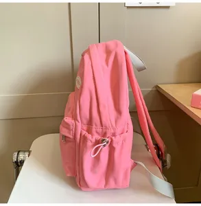 Seitenansicht eines süßen rosa Mini-Rucksacks mit kompakter Struktur und praktischer Tasche.