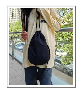 Black nylon drawstring crossbody bag, casual dumpling shoulder bag for daily street wear.