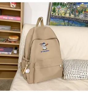 Casual canvas backpack with cute embroidered puppy and baseball charm for daily school travel.