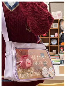 Purple crossbody ita bag with transparent window, cute plush pendant and badge display space.