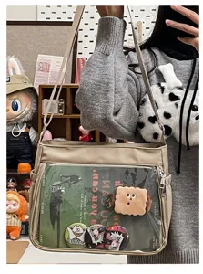 Casual versatile beige canvas crossbody ita bag with clear front window for pins and badges.