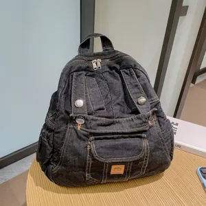 Detail view of dark denim casual backpack featuring multi pockets and vintage style design.