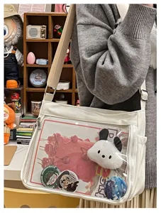 Clear transparent window ita bag detail showing custom anime badges and cute puppy plush accessory.