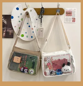 Clear window ita bag detail showing transparent front pocket for pins and cute plush charms.