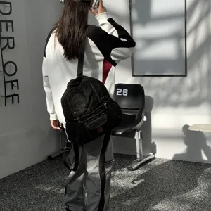 Detailed view of the black denim backpack showcasing multi-pocket design and vintage style.