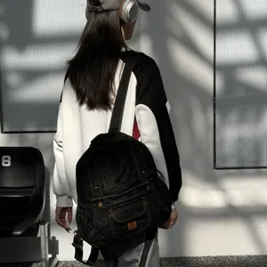 Detailed lifestyle shot of a stylish dark denim backpack worn on model, vintage daily wear.