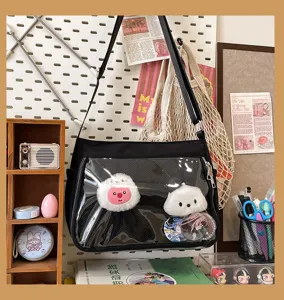 Detail view of black Ita bag featuring transparent front window for anime badges.