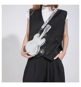 Guitar shaped silver crossbody bag detail view, unique shiny metallic finish and strap design.