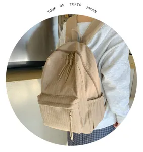 Vue détaillée du sac à dos de campus kaki élégant, doté d'un tissu texturé et de doubles fermetures.