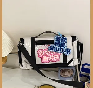 Details of black white ita messenger bag with transparent window and cute accessories inside.