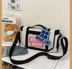Detail shot of white black ita bag with clear window and funny patches for daily use.
