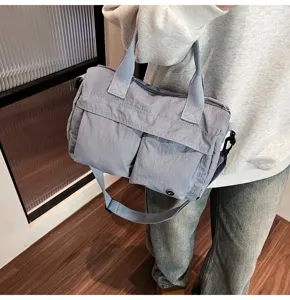 Λεπτομερής παρουσίαση της casual γκρι νάιλον τσάντας χιαστί με διπλή μπροστινή τσέπη.