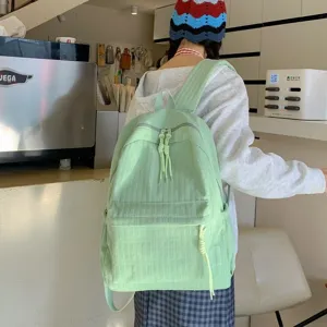 Vue détaillée du sac à dos étudiant vert clair avec multiples poches et design tendance.