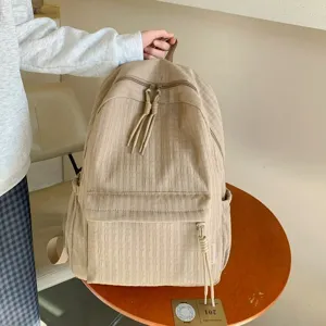 Détail du sac à dos décontracté plissé avec texture et poche avant pour le trajet quotidien.