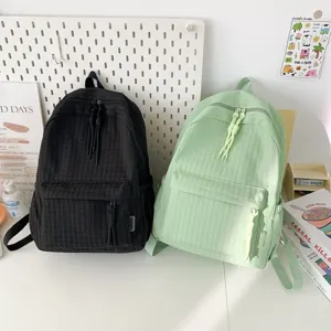 Vue détaillée de beaux sacs à dos d'étudiants style japonais en noir et vert clair.