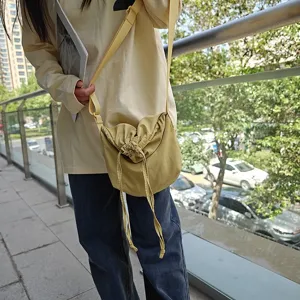 Yellow nylon crossbody dumpling bag with drawstring, casual street style daily shoulder bag.