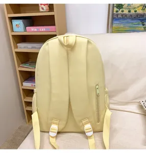 Casual yellow student backpack detail view, showing back straps, adjustable buckles and side pocket.