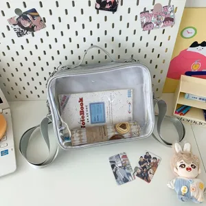 Clear front crossbody ita bag detail shot, transparent window design for pins and cards display.