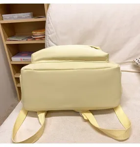 Detail view of the light yellow school backpack bottom and adjustable straps, casual bag.