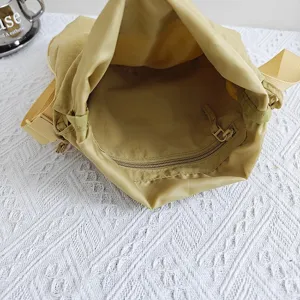 Close-up view of the spacious interior compartment and zipper pocket of a casual nylon dumpling bag.