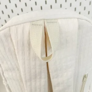 Gros plan detaille de la poignee superieure du sac a dos blanc texture et coutures.