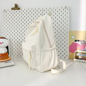 Vue détaillée latérale du sac à dos minimaliste beige avec poches multiples.