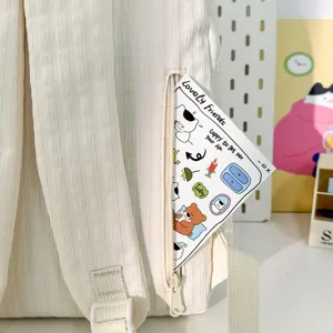 Gros plan détaillé du sac à dos beige clair avec poche zippée et jolie carte.