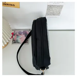 Side detail view of a black clear ita bag, showcasing double zipper structure and strap.