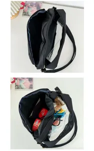 Detailed view of the black canvas transparent ita bag showing dual zipper compartments and window.