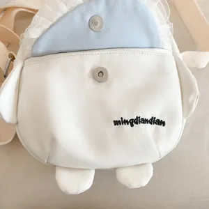 Gros plan détail du sac bandoulière en toile chiot mignon avec volants et broderie.