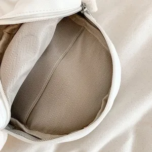 Détail intérieur de sac bandoulière blanc décontracté avec doublure à chevrons résistante.