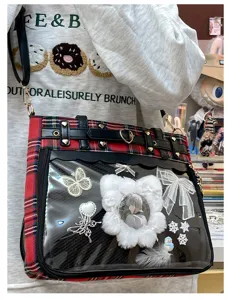 Details of Japanese plaid ita bag with clear window and cute anime pin charms for daily use.