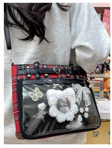 Detail shot of Japanese anime style red plaid ita bag with clear window and cute badges.