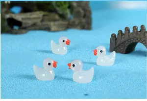 Close-up detail of luminous resin little duck ornaments for moss micro landscape decor.